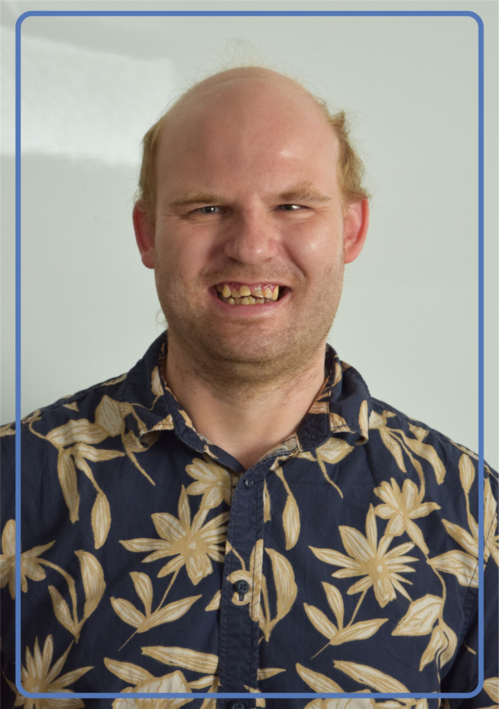 Portraitfoto eines jungen Mannes mit blauem Hemd und blonden haaren
