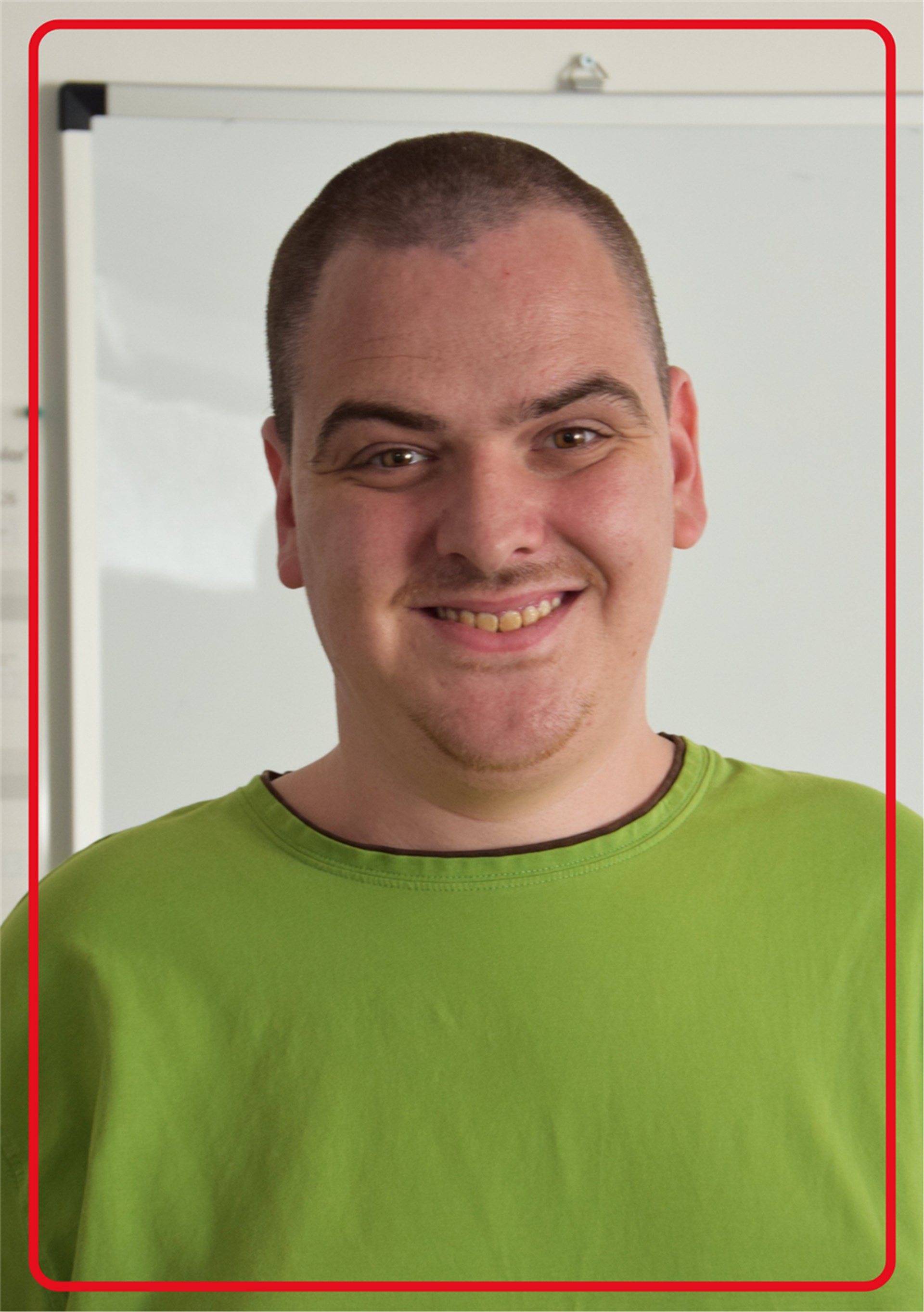 Portraitfoto eines Mannes mit dunklen kurzen haaren und einem grünen Shirt